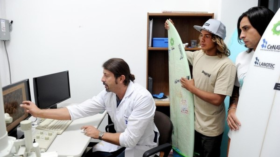 José Vega, director del Lanotec, explica a los surfistas Óscar Urbina y Jordi Solís cómo son las celdas del nuevo poliuretano a partir de una imagen captada por el microscopio electrónico de barrido.  Melissa Fernández / Grupo Nación